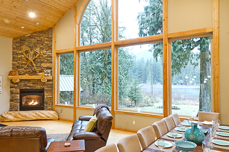 Vaulted cedar ceiling, stone fireplace and lake-view windows inside a Kestrel custom home