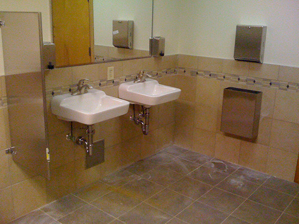 A commercial restroom remodel with new wall-mounted sinks